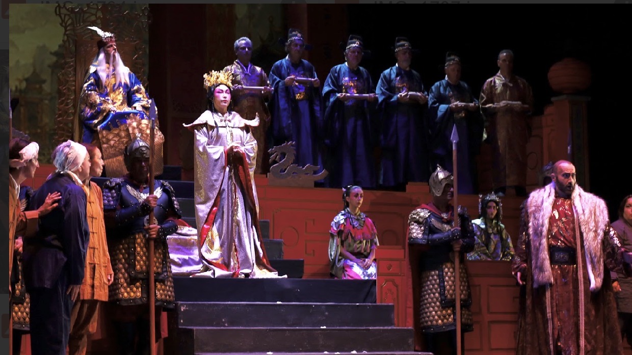 Turandot sulla scalinata, con la corte e le guardie.